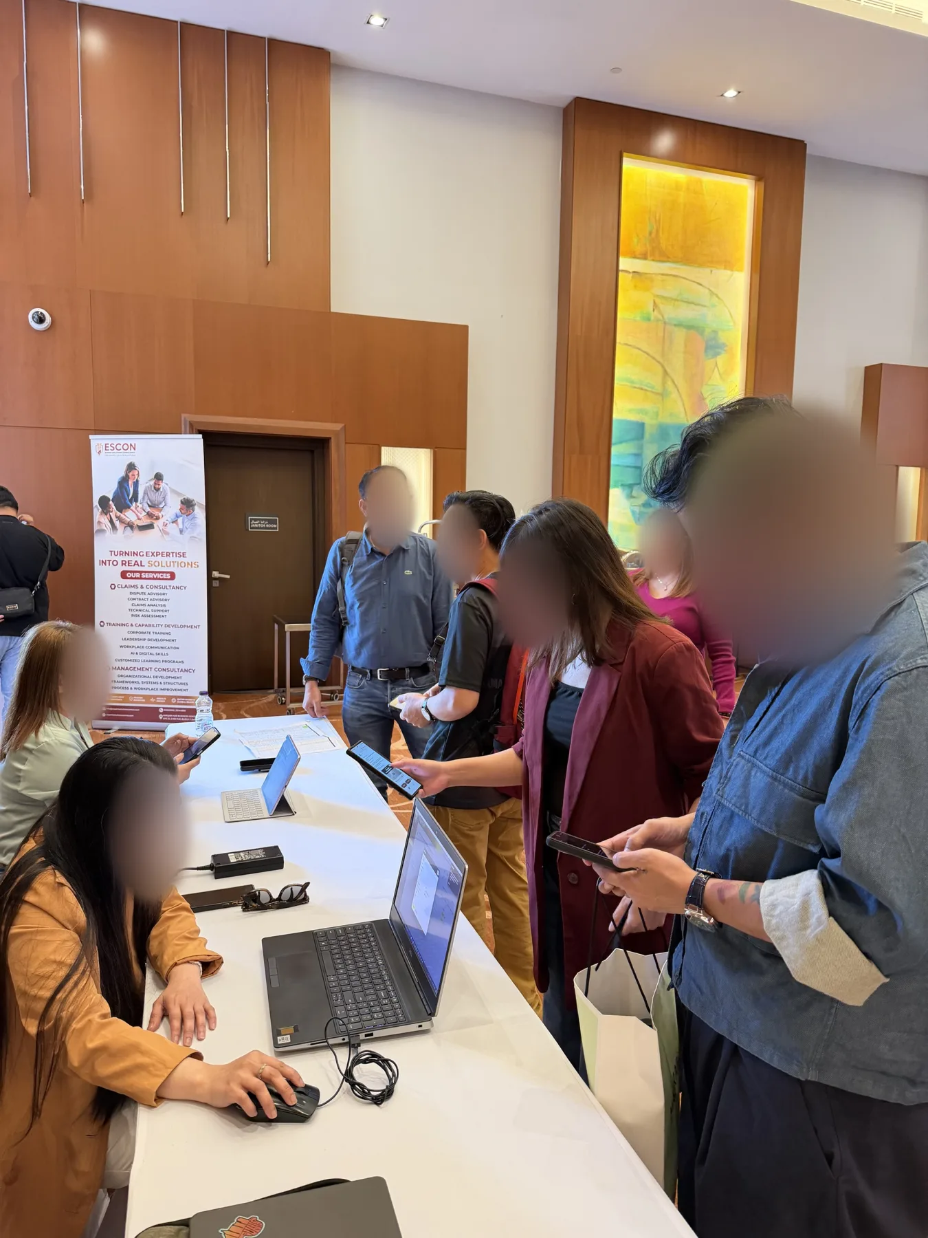 Attendees scanning QR codes on their phones at the registration desk