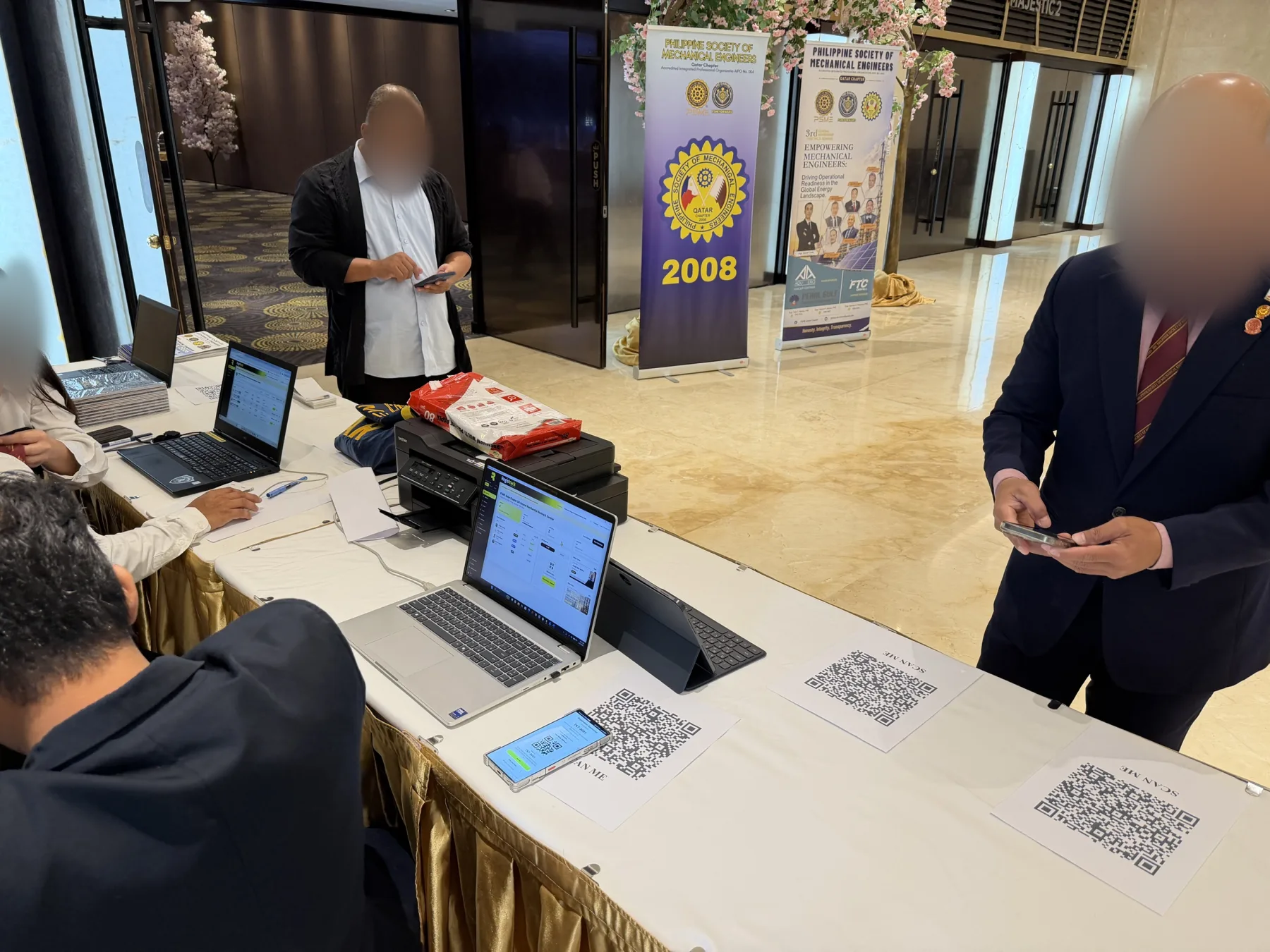 Attendees checking in at a registration table with RegisTrack laptops and QR codes